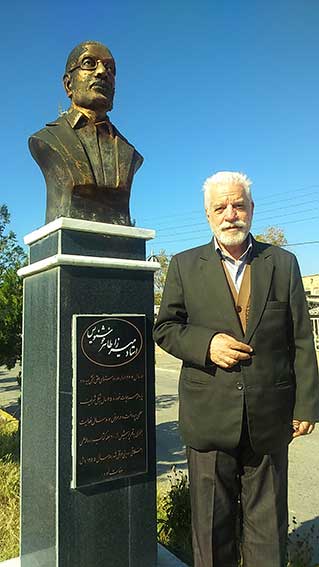 دکتر حسین محمدزاده صدیق در کنار مجسمه میرزا طاهر خوشنویس- روستای سیه رود