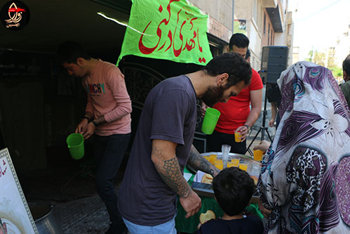 خادمین هیئت زوارالحسین در حال پذیرایی از مردم درایستگاه صلواتی شهیددولت آبادی جشن نیمه شعبان98